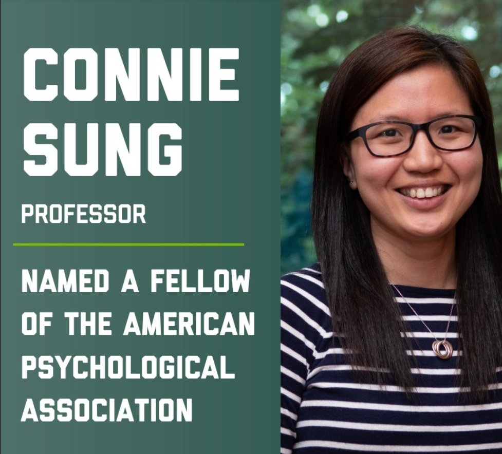 Woman in striped shirt and glasses smiling at the camera.